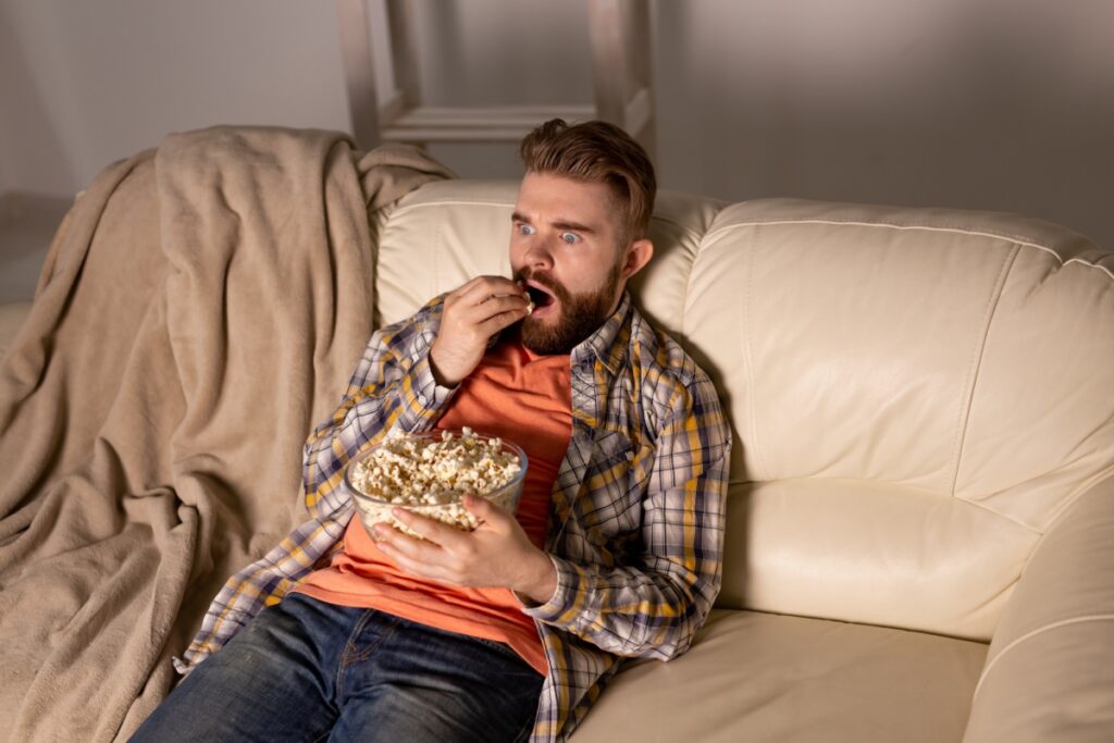 Single man on the couch watching TV