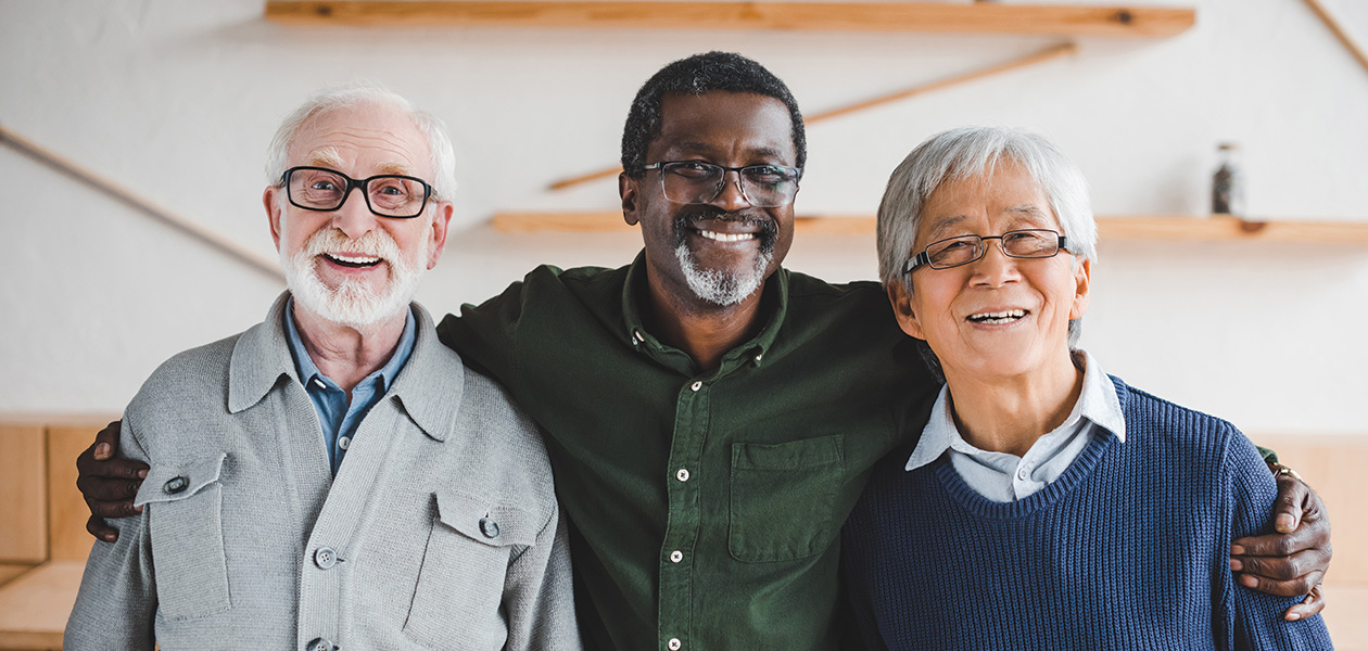three senior men smiling and embracing indoors 2026 01 06 00 43 56 utc